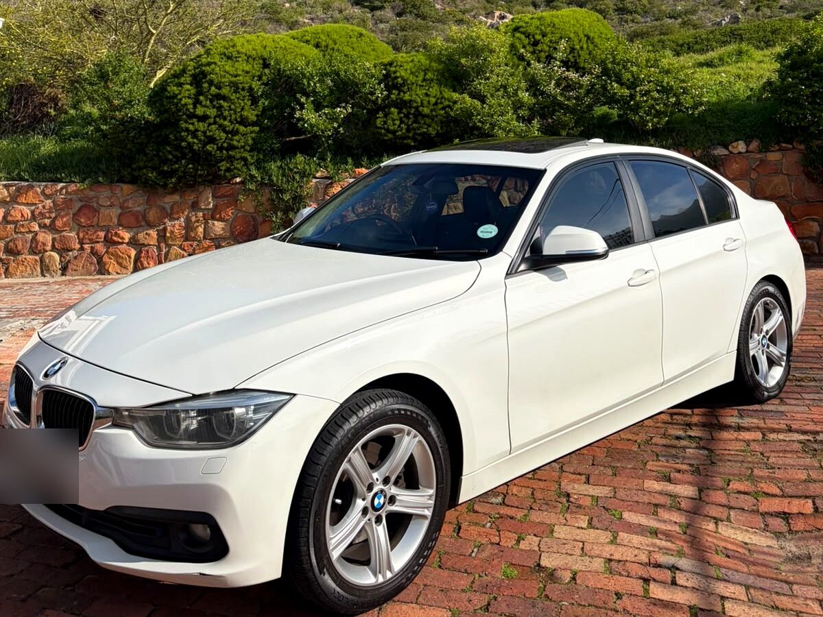 White BMW 3 Series sedan below the mountains